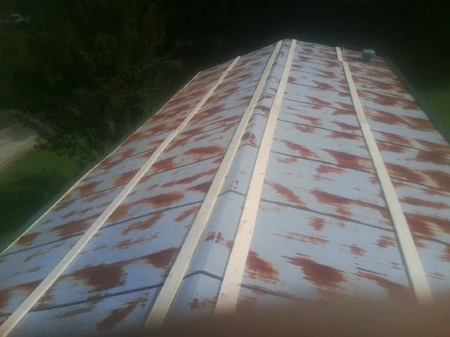Rusted metal roof panels with new wood purlins before replacement — Storm Damage Roof Repair in Beemer by Roofing Brothers