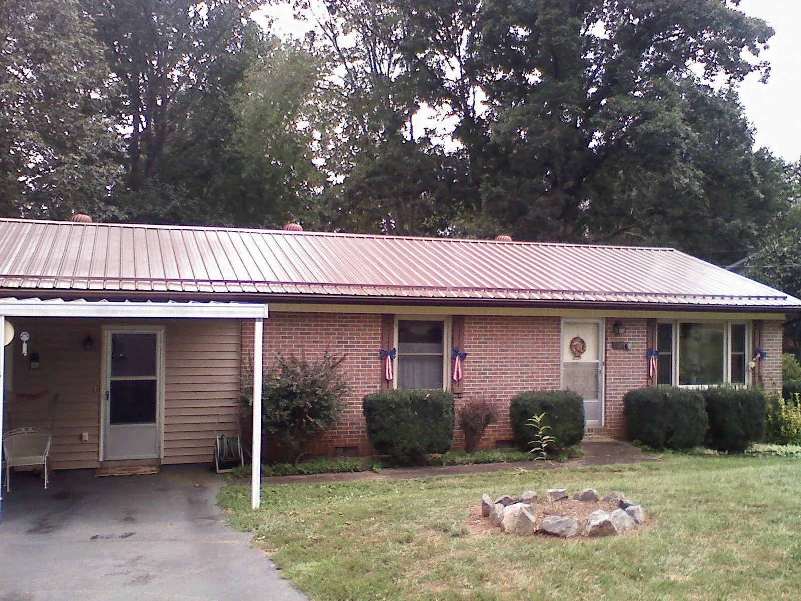 Bronze metal roof and carport on a brick ranch home — Roof Repair work by our crew in Beemer